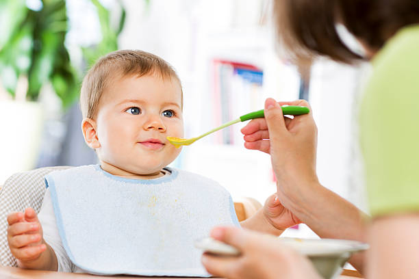 istock Joyous baby boy starting eating food. 452256995
