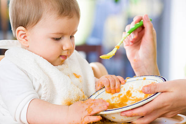 istock Sweet messy baby boy playing with food while eating. 452257005