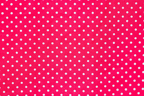 istock White polka dots on red fabric. 452269503