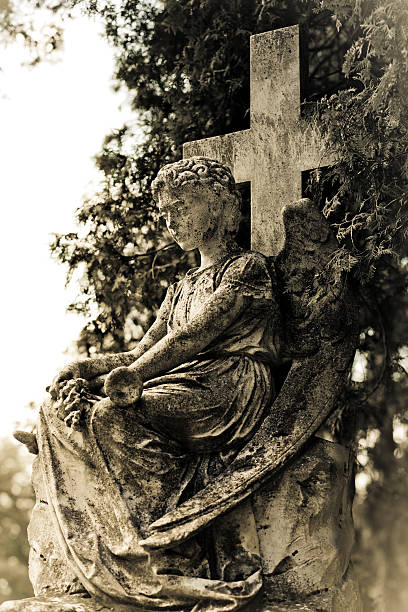 istock Sitting Archangel and cross on tombstone 452270199