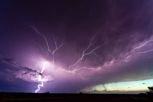 istock Lightening veining across stormy purple sky 452346939