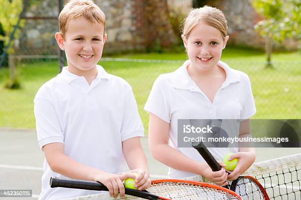 Photo libre de droit de Deux Jeunes Amis Avec Raquettes Sur Souriant De Tennis Court banque d'images et plus d'images libres de droit de Activité