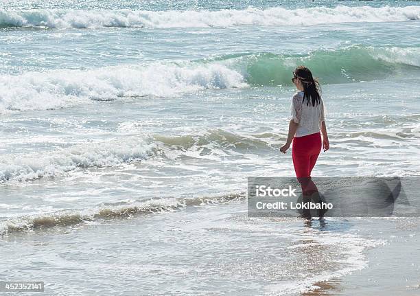 Молодая Женщина В Воде На Пляже — стоковые фотографии и другие картинки Брюки - Брюки, Люди, Один человек