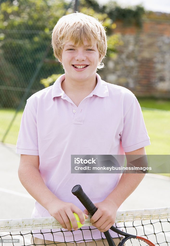 Junge mit Schläger auf tennis Gericht lächelnd - Lizenzfrei Aktiver Lebensstil Stock-Foto