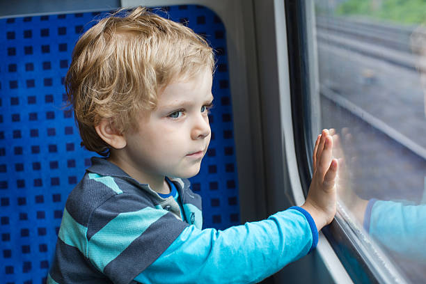 istock Cute little boy looking out train window 452355033