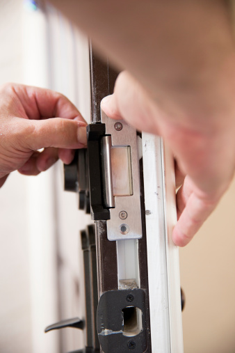 Contractor installing a security lock on door.  