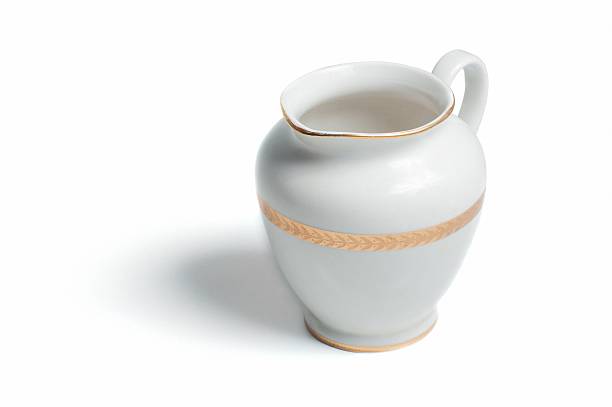 Retro porcelain milk jug isolated on the white background with shadow.