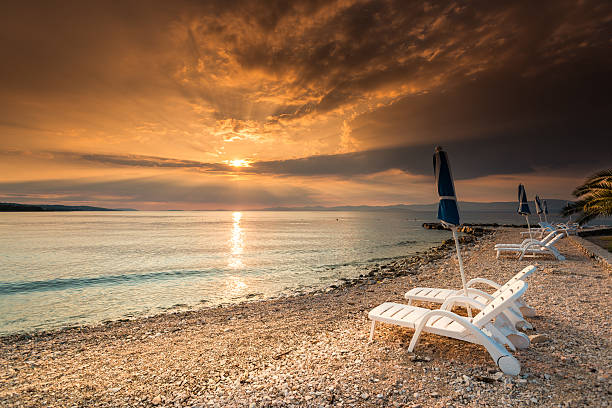 istock Beach loungers on the coast sea at sunset 452356861