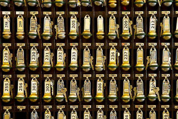 Hotel room key station with three rows of keys in view hotel front desk key rack. Focus on the top row of keys bellhop photos stock pictures, royalty-free photos & images