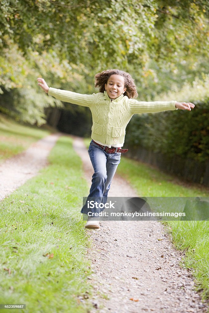 Jovem a correr em um caminho ao ar livre a sorrir - Royalty-free Criança Foto de stock