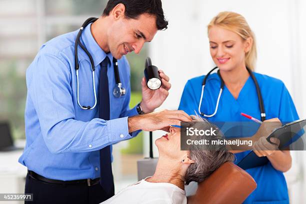 Ophthalmologist Examining Senior Womans Eye Stock Photo - Download Image Now - 70-79 Years, 80-89 Years, Adult