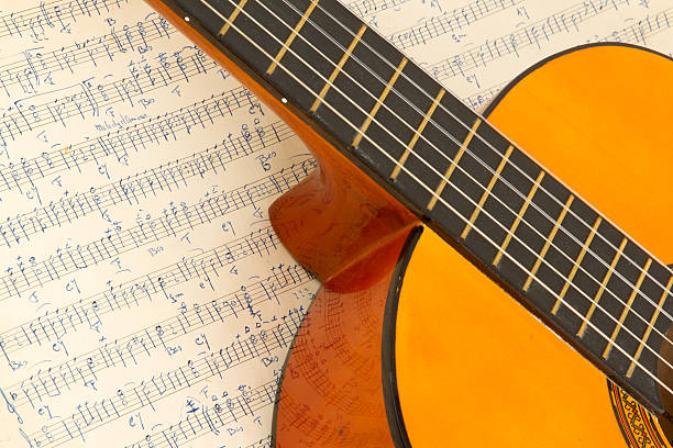 istock Old music sheet and a guitar 452365677