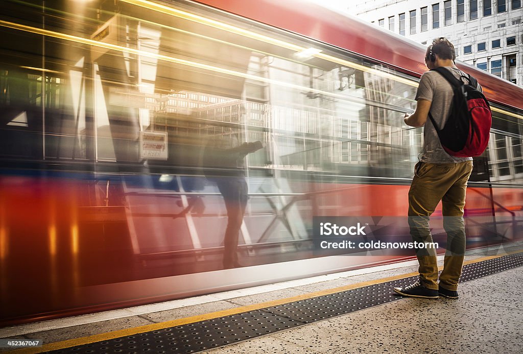 Young man with backpack waiting for train Young man wearing headphones waiting for the train Headphones Stock Photo