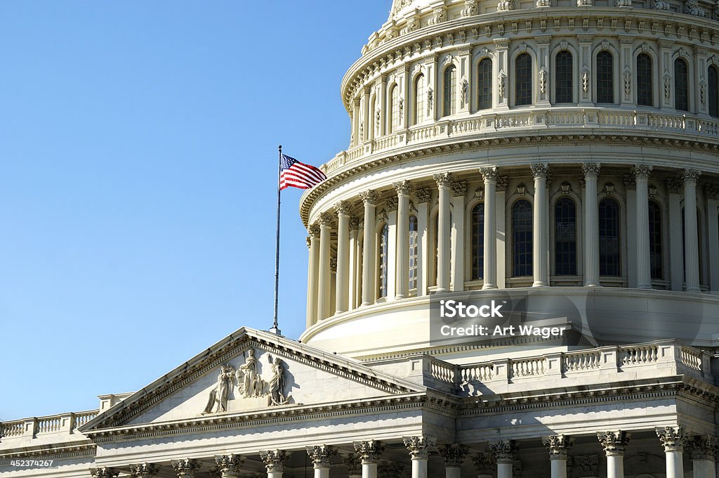 United States Capitol Building A close up view of the dome of the U.S. Capitol Building with the American Flag flying; Washington DC, the United States of America. American Flag Stock Photo