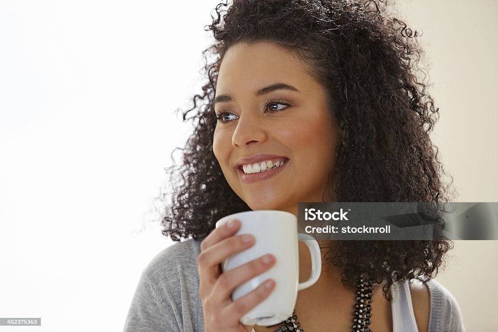 Pretty young lady with coffee and looking away smiling Pretty young lady with coffee and looking away at copyspace smiling 20-24 Years Stock Photo