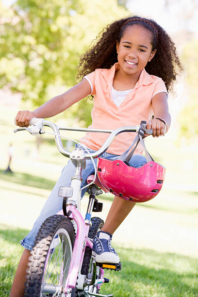 istock Young girl on bicycle outdoors smiling 452375981
