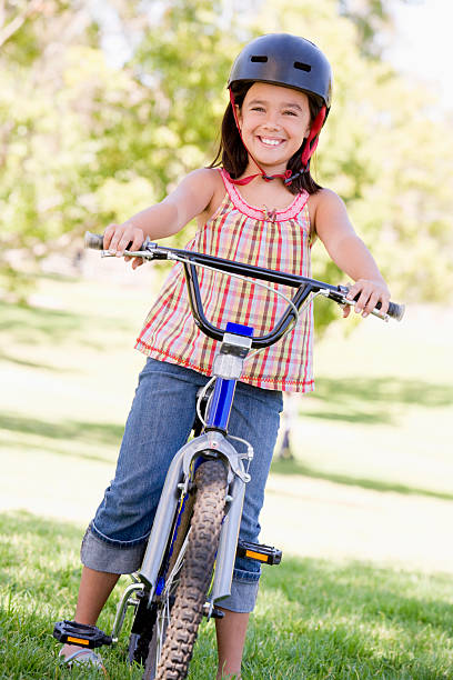 istock Young girl on bicycle outdoors smiling 452376001