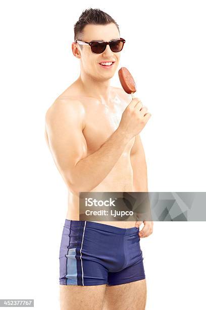 Młody Człowiek W Strój Kąpielowy Trzymając Z Lodami - zdjęcia stockowe i więcej obrazów Bez koszulki