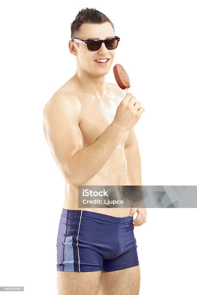 Jovem homem em traje de banho segurando um sorvete - Foto de stock de Acessório ocular royalty-free