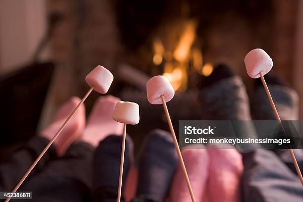 Füße Erwärmung Am Kamin Mit Marshmallows Auf Sticks Stockfoto und mehr Bilder von Offenes Feuer