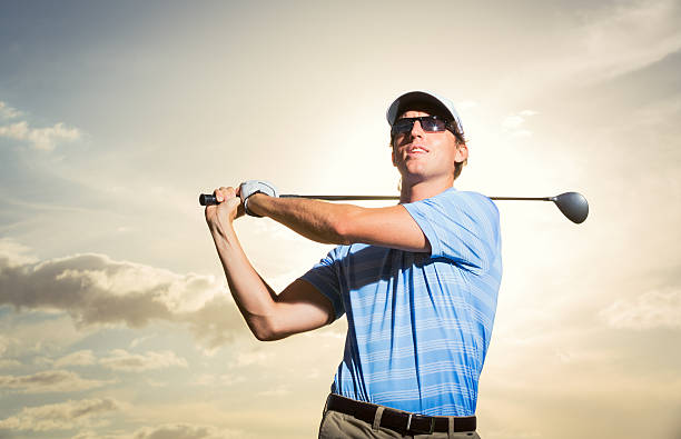 istock Young man swinging golf club 452387257