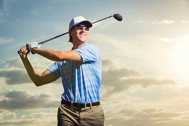 istock Young man swinging golf club 452387339