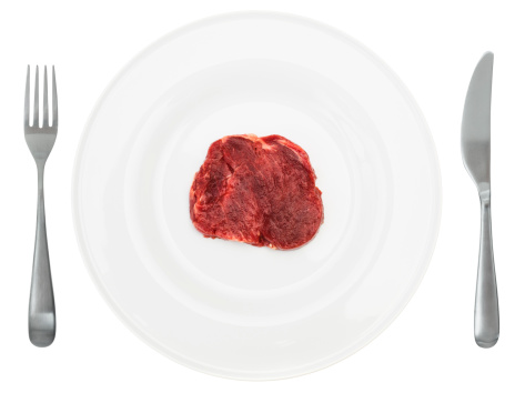 Fillet Mignon is sprinkled with salt and spices on a fork. Medium roasting