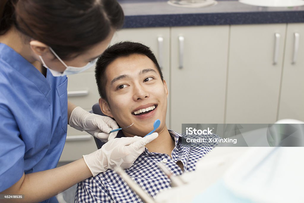 Male Patient Receiving Treatment In Clinic Dentist Stock Photo