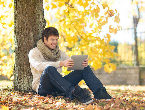istock man with tablet pc in autumn park 452418875