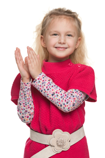 A closeup portrait of a cheerful little girl that applauds