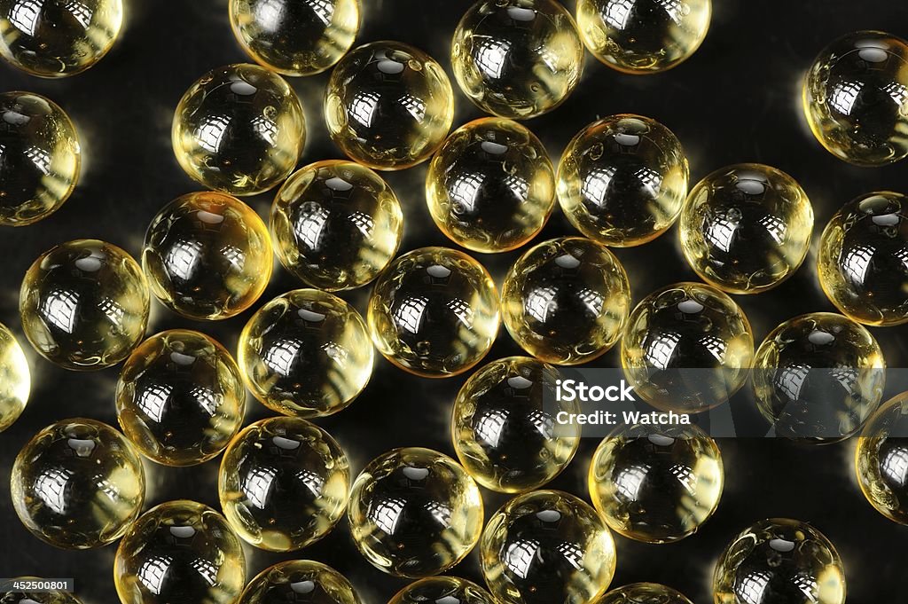 Kapsułki oleju makro na czarnym tle - Zbiór zdjęć royalty-free (Bez ludzi)