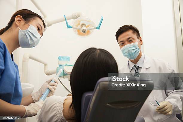 Dentists Examining Female Patient Stock Photo - Download Image Now - Dentist, China - East Asia, Chinese Ethnicity