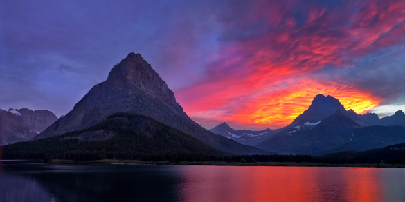 Clearing skies at sunset create a fiery drama at Montana's Glacier National Park.  The view is of Mount Grinnel and Swiftcurrent Lake as seen from the patio of the Many Glacier Hotel.