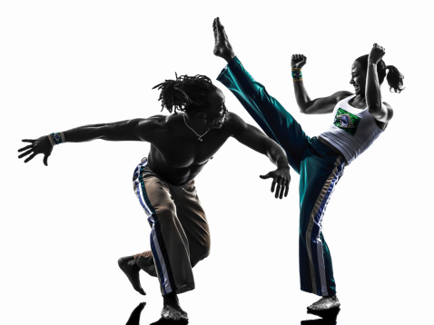 two people couple capoeira dancers dancing in silhouette studio on white background