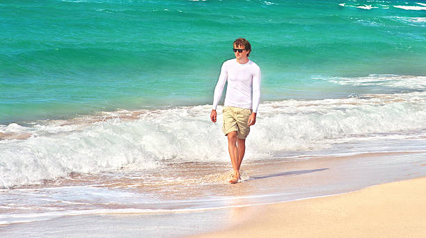 istock Young Man walking on the Beach Seaside sand with sea 452510309