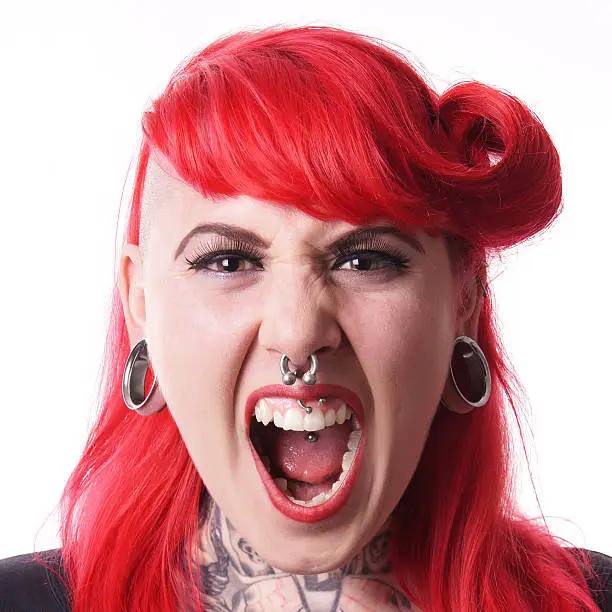 young woman with flesh tunnel, septum and medusa piercings