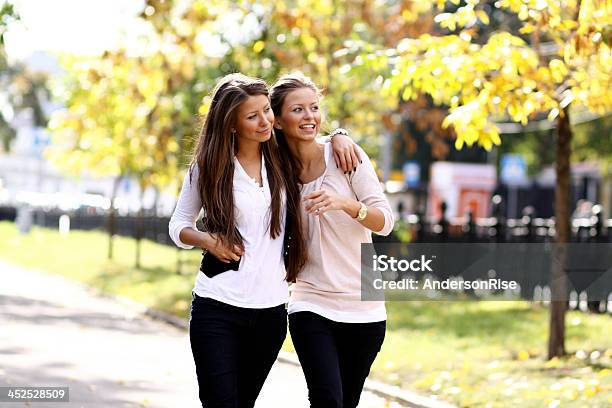 Two Cheerful Girls Twins In The Street Stock Photo - Download Image Now - Adult, Autumn, Close-up