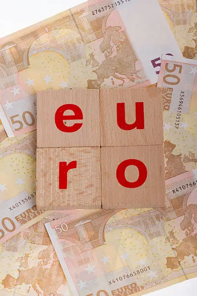 Letter on blocks on top of some 50 euro banknotes