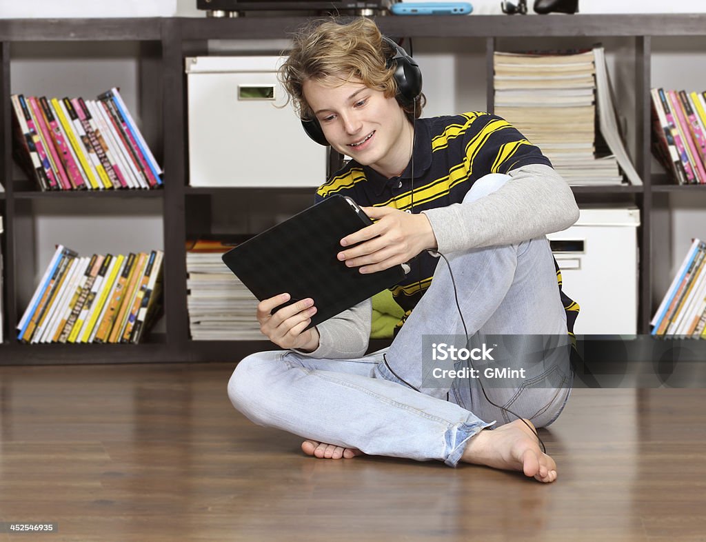 Jeune garçon se détendre en écoutant de la musique avec tablette numérique. - Photo de Adolescence libre de droits