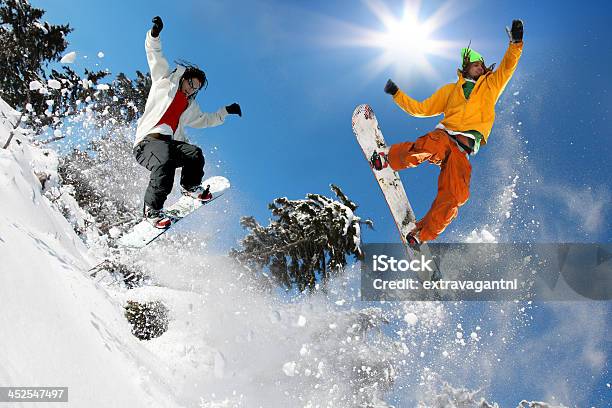 Сноубордисты Прыжки Против Голубого Неба — стоковые фотографии и другие картинки Сноуборд - Сноуборд, Прыгать, Сноубординг