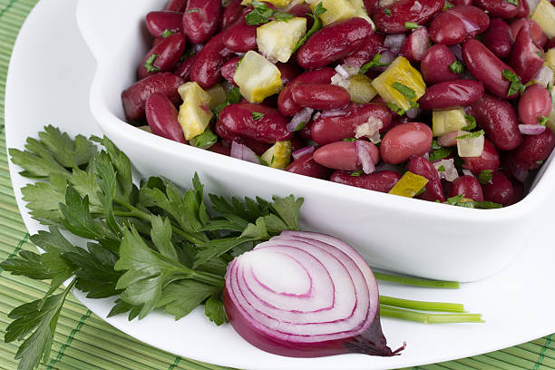 barbunya pilaki are served cold, garnished with parsley and slices of lemon.