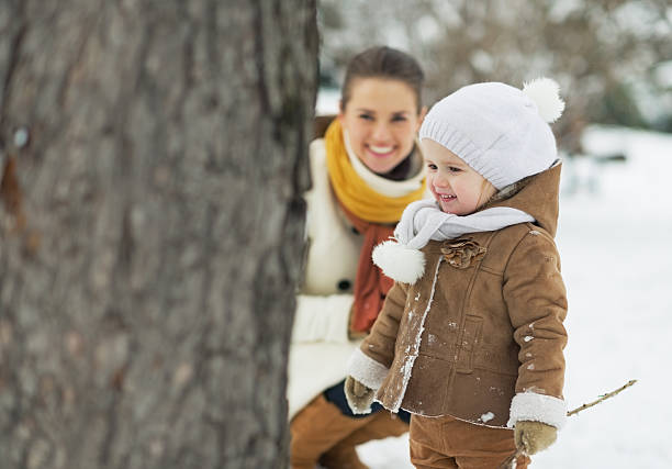istock Happy mother playing with baby in winter park 452549655