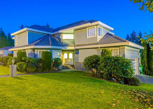 istock Big white house at dusk, view from green garden 452555555