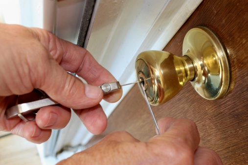Maintenance man examining front door lock of an apartment in the apartment building