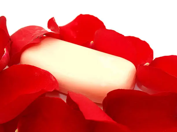 Soap in rose-petals on a white background