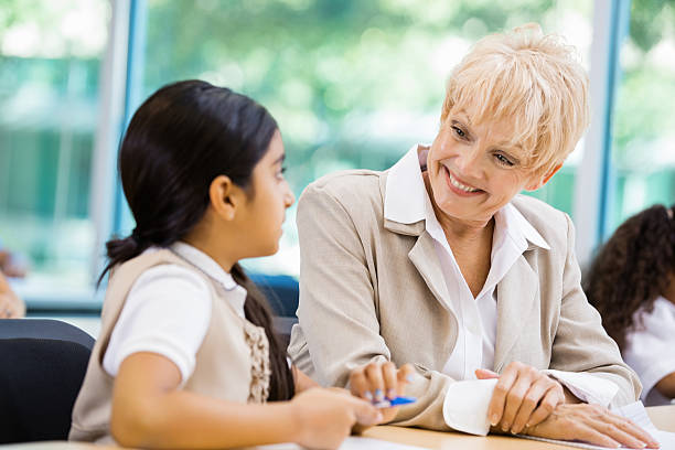 istock Senior teacher tutoring student in private school classroom 452584755