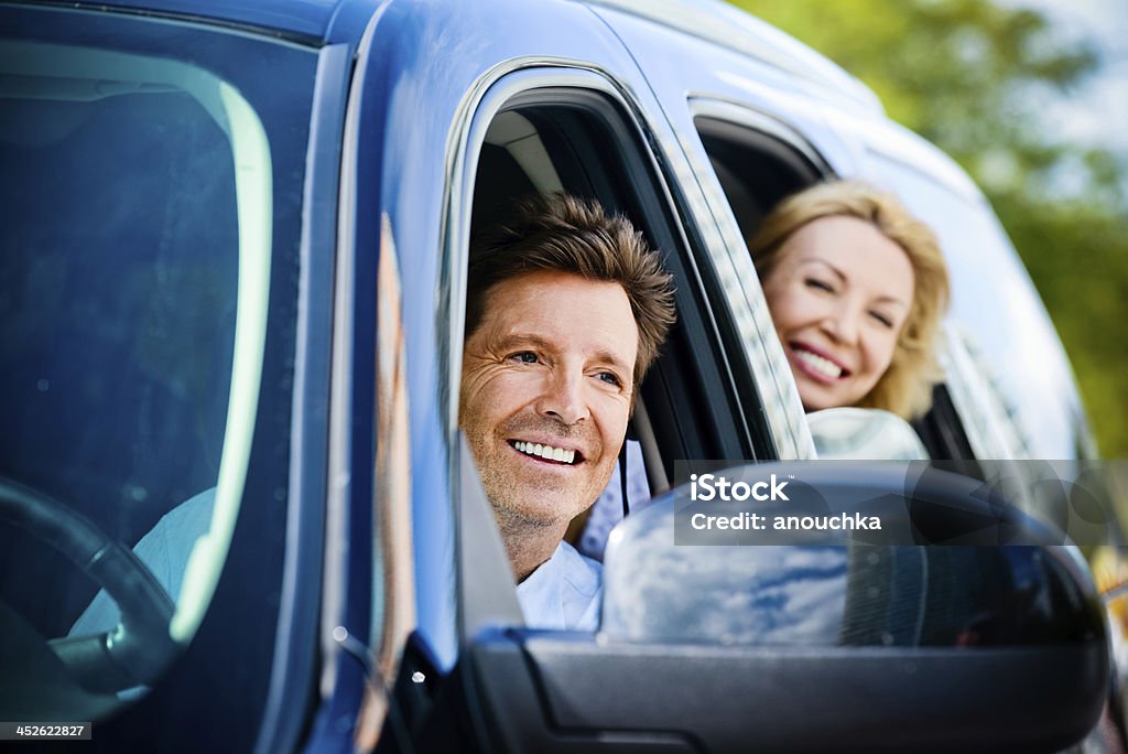 Happy Mature Couple ready to travel in a their car 40-44 Years Stock Photo