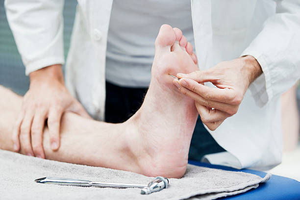 Doctor testing sensibility of foot stock photo