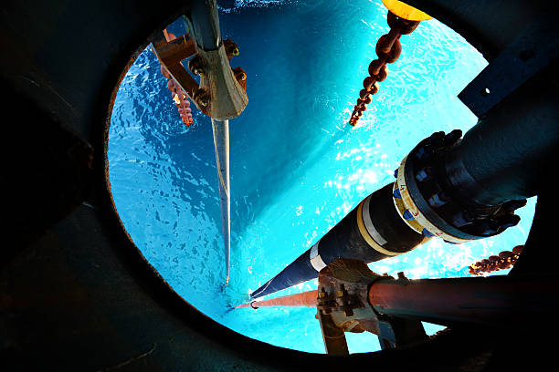Offshore drilling rig Offshore drilling rig for oil and natural gas extraction, downward view on the blue sea where fishes swim. natural gas extraction stock pictures, royalty-free photos & images