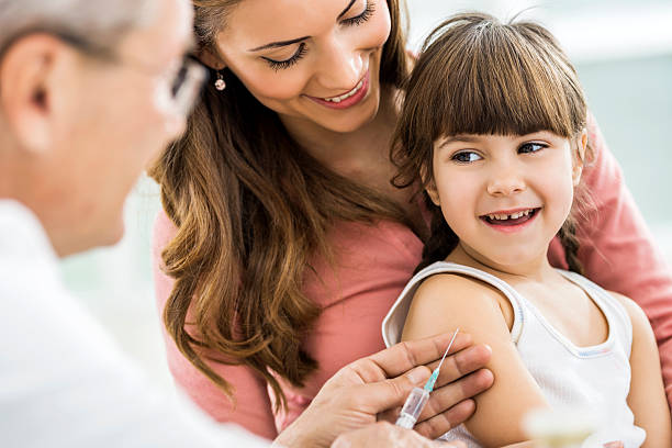 Little girl with mom, about to receive injection Mother and daughter at the doctor's. Little girl is receiving a vaccine.    injecting flu virus vaccination child stock pictures, royalty-free photos & images